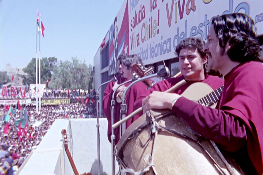 Músicos de Inti - Illimani tocan en el antiguo balcón de la casa central de la Universidad Técnica del Estado. Aparecen con ponchos amarantos y el público que llena la explanada central