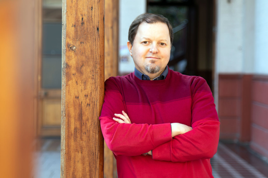 Académico Dr. Juan Carlos Pina, investigador del Departamento de Ingeniería en Obras Civiles. En la fotografía, el investigador aparece con un chaleco rojo, apoyado a una viga.