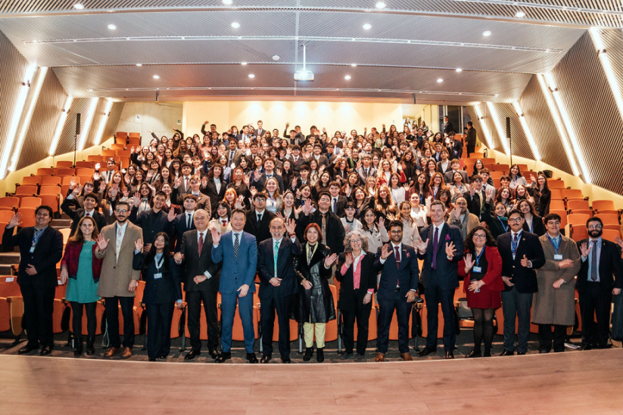 En la fotografía aparece el Rector Vidal junto autoridades del gobienro de Chile,, de las embajadas de EEUU y la India, más los estudiantes que participaron del evento. El escenario es el Auditorio FAE.