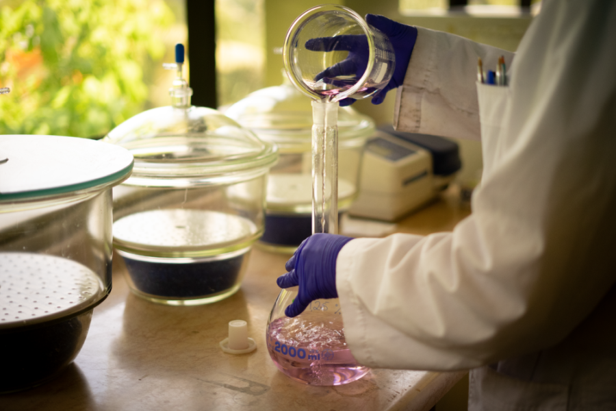 En la fotografía aparece un científico manipulando objetos de vidrio que corresponden a un laboratorio de ciencia