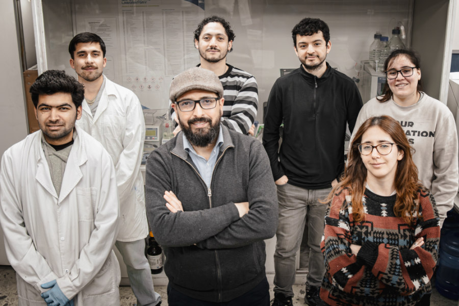 El Dr. Esteban Quijada, académico del Departamento de Ingeniería Química y Bioprocesos de la Universidad de Santiago de Chile, posa junto a su equipo de investigadores. En total, son 6 personas que rodean al investigador.