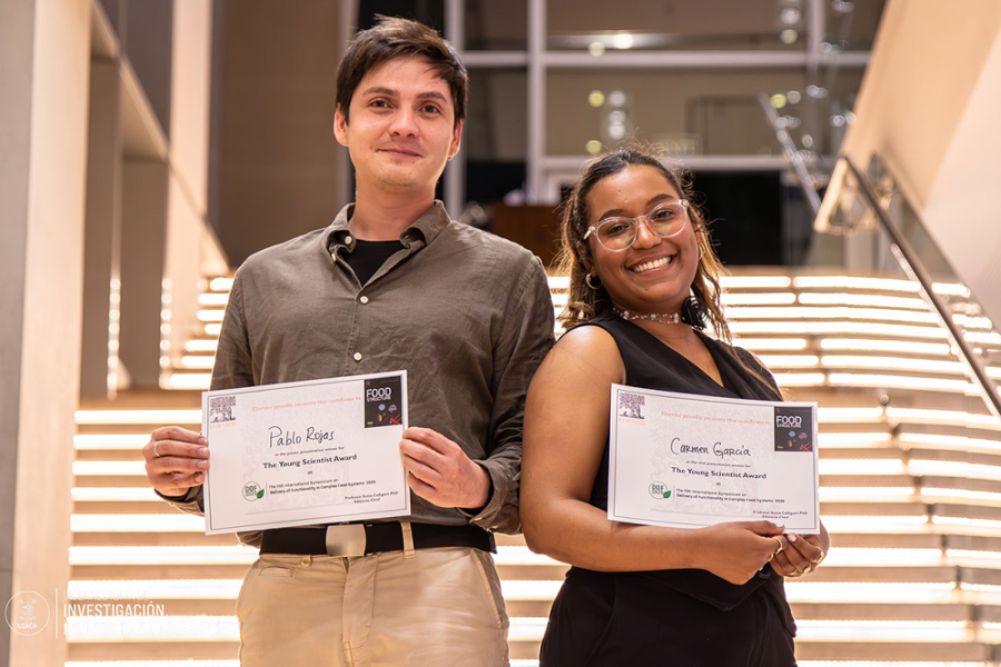 En la imagen aparecen los dos estudiantes de doctorado premiados. De fondo una escalera