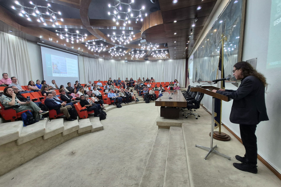 Académico Mario Sobarzo se dirige al público del evento en el Salón de honor Usach
