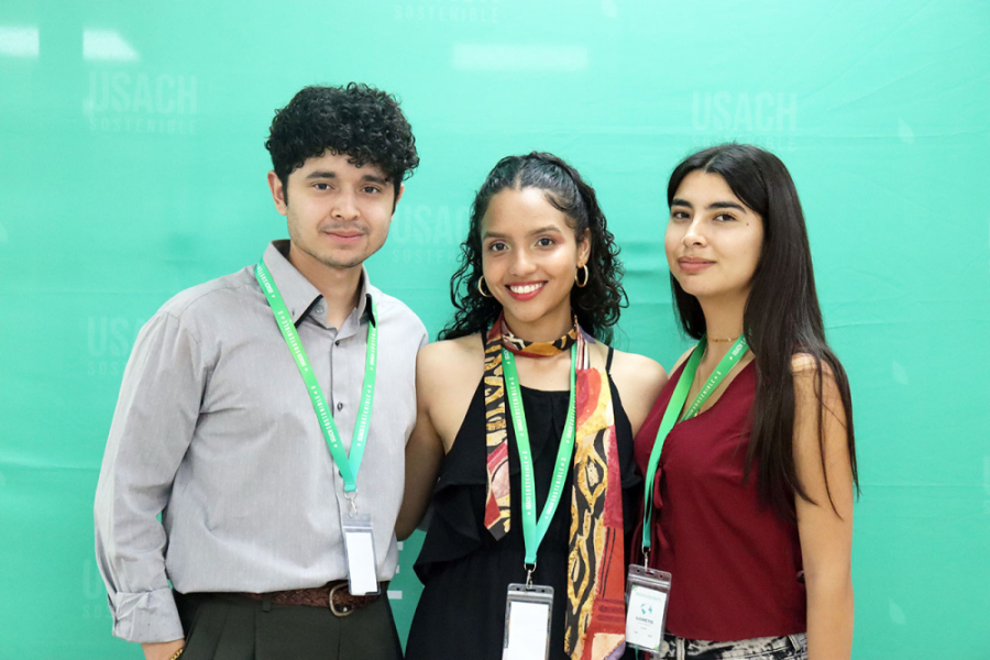 De izquierda a derecha: hombre y dos mujeres posan adelante de un fondo turquesa