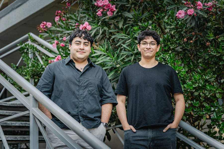 en la imagen aparecen dos estudiantes de Usach Premium en las escaleras del edificio de la antigua FAE