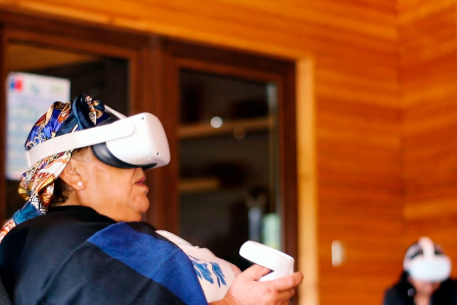 En la imagen aparece una integrante de la comunidad mapuche con unos lentes de realidad virtual.