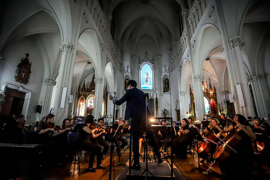 En la imagen se muestra una orquesta tocando en una iglesia 