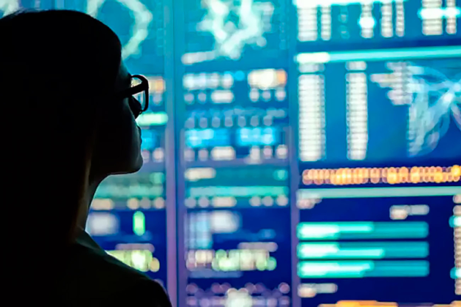 La sombra de un hombre mira la pantalla de una gran computadora