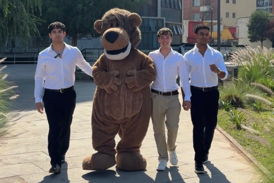 En la foto aparecen los tres estudiantes de la organización, caminando junto a Usachín por el patio de la FAE