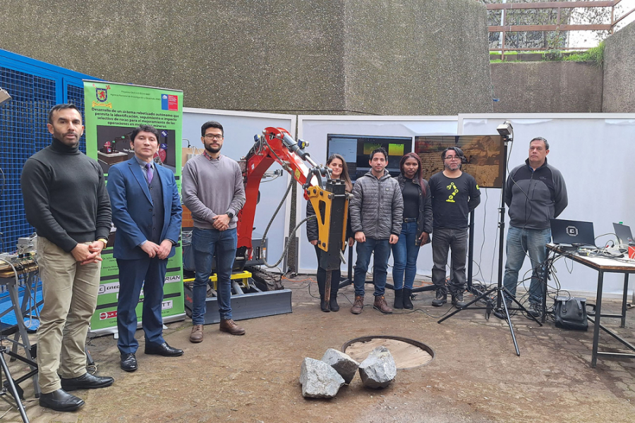 En la imagen aparecen los investigadores a cargo del proyecto, posando junto a una máquina rompe rocas y equipo tecnológico para presentar la investigación 