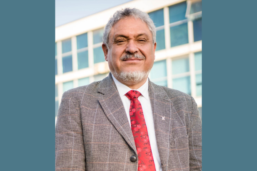 La imagen corresponde a Pedro Palominos mirando a la cámara con terno gris y corbata roja