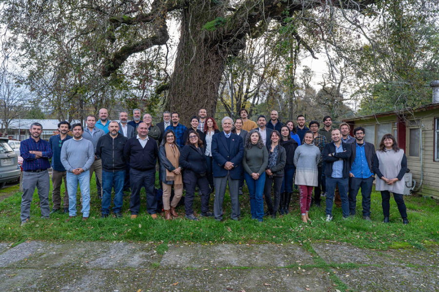 En la imagen aparecen las y los científicos que forma parte del nuevo centro de investigación. Son alrededor de 50 personas. De fondo un gran árbol los acoge con sus tronco y ramas.