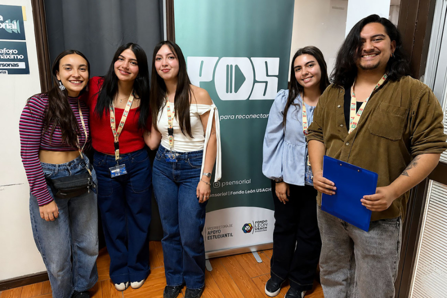 en la imagen aparece estudiantes mujeres del evento junto al pendón de la actividad.