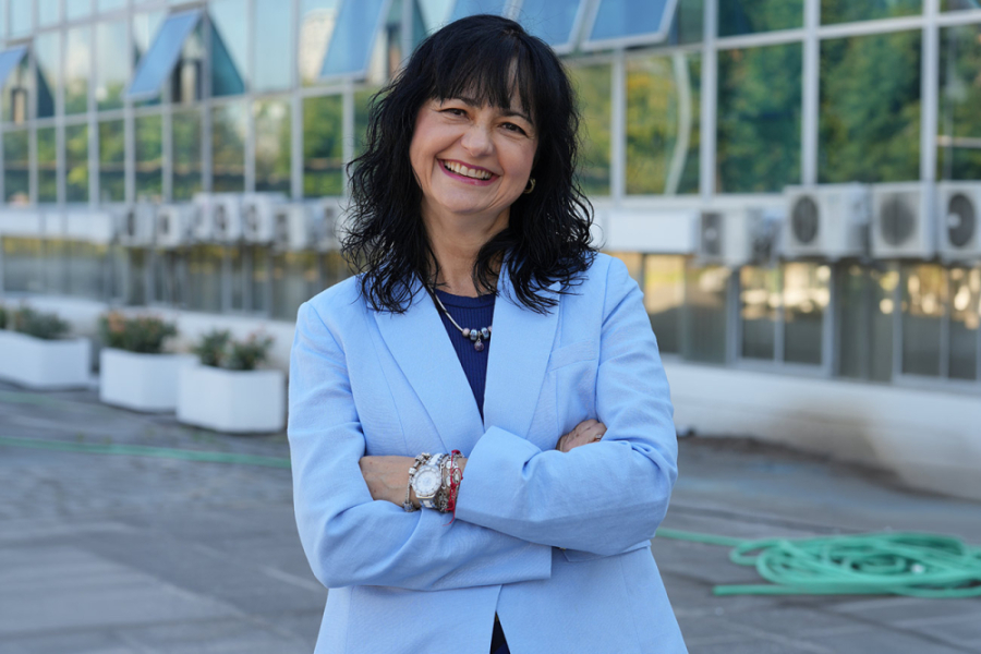 En la fotografía aparece la nueva decana de la Facultad de Ciencia, la Dra. Galina García Mokina. Aparece brazos cruzados , una chaqueta gris y de fondo el frontis de la casa central de la universidad