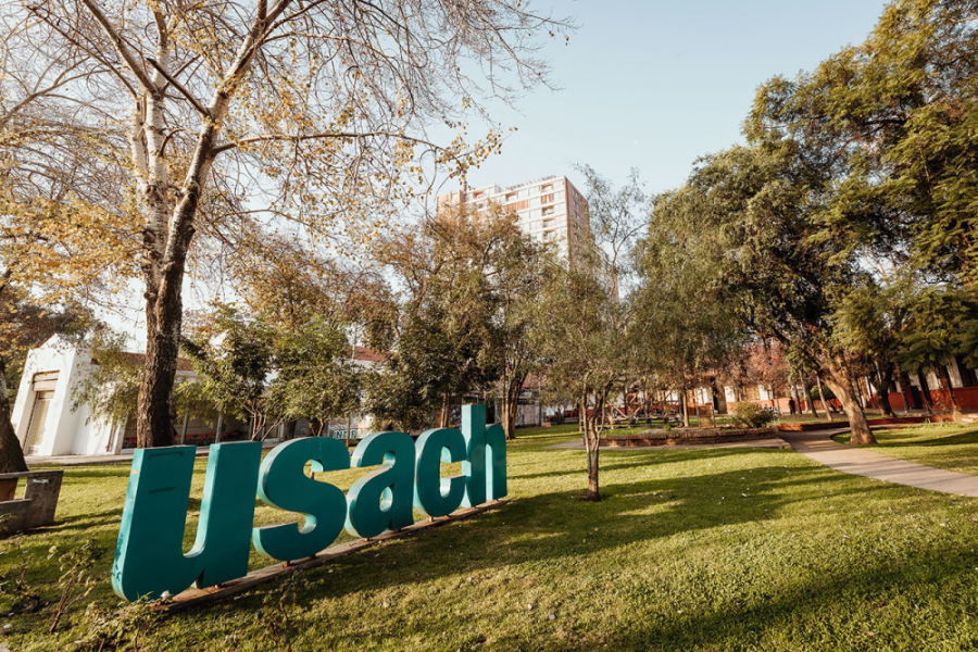 En la imagen aparece las letras instituciones USACH en color turquesa, en los patios de la EAO