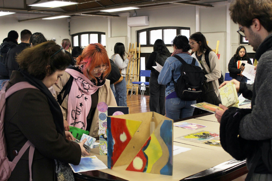 La imagen muestra a distitnas personas observando las obras en la galería 