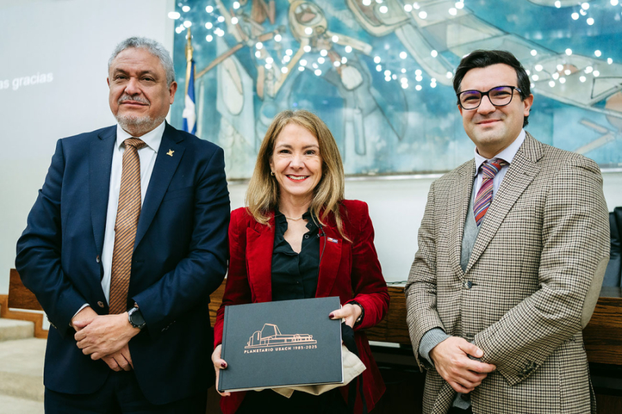 La imagen muestra a la presidenta de la CPC sosteniendo un regalo en sus manos, junto al rector Dr. Pedro Palominos (izquierda) y al decano de la facultad, Raúl Berríos (derecha)