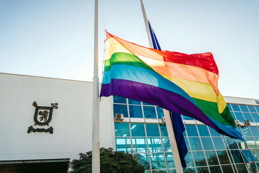 En la imagen aparece la bandera de la diversidades. De fondo, la fachada de la casa central Usach