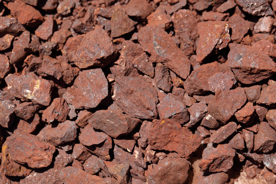 Detailed top-down view of reddish-brown iron ore gravel rocks.