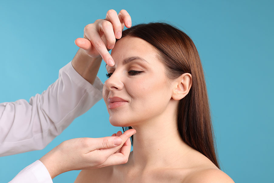 Un especialista examina los rasgos faciales de una mujer.