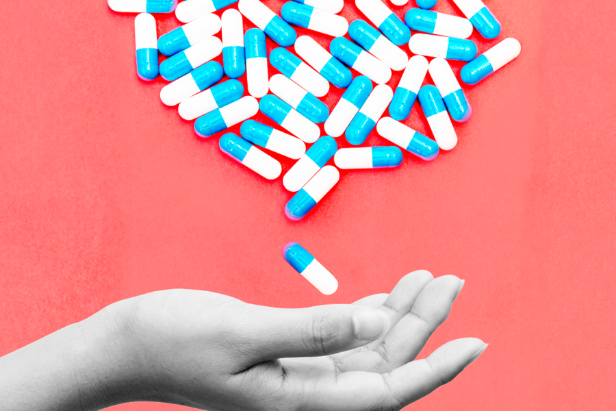 Mano extendida recibiendo pastillas.