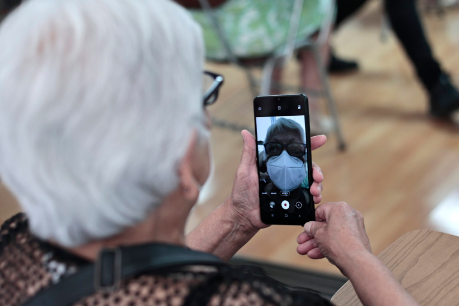 Mujer de la tercera edad revisando una app en su celular.
