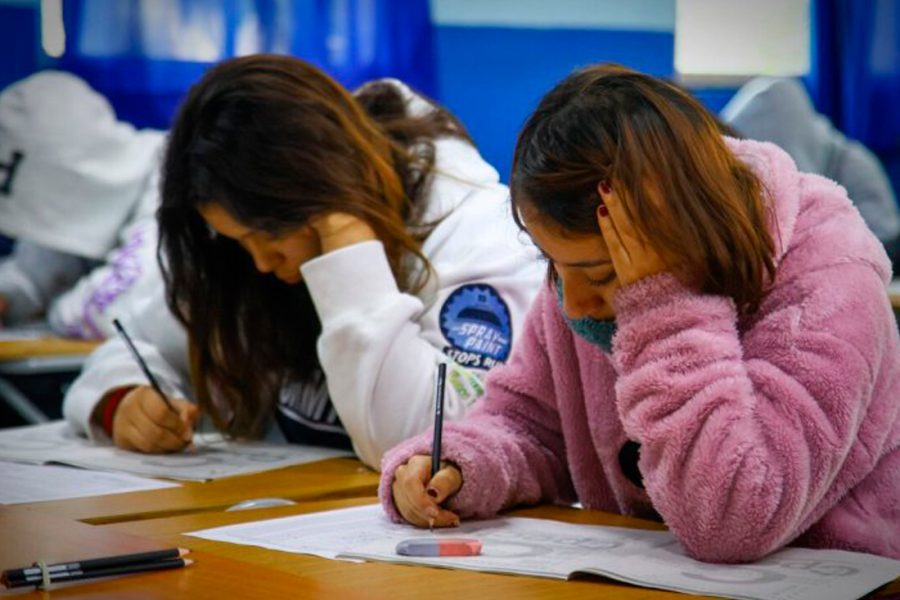 Estudiantes anotando en su cuaderno.