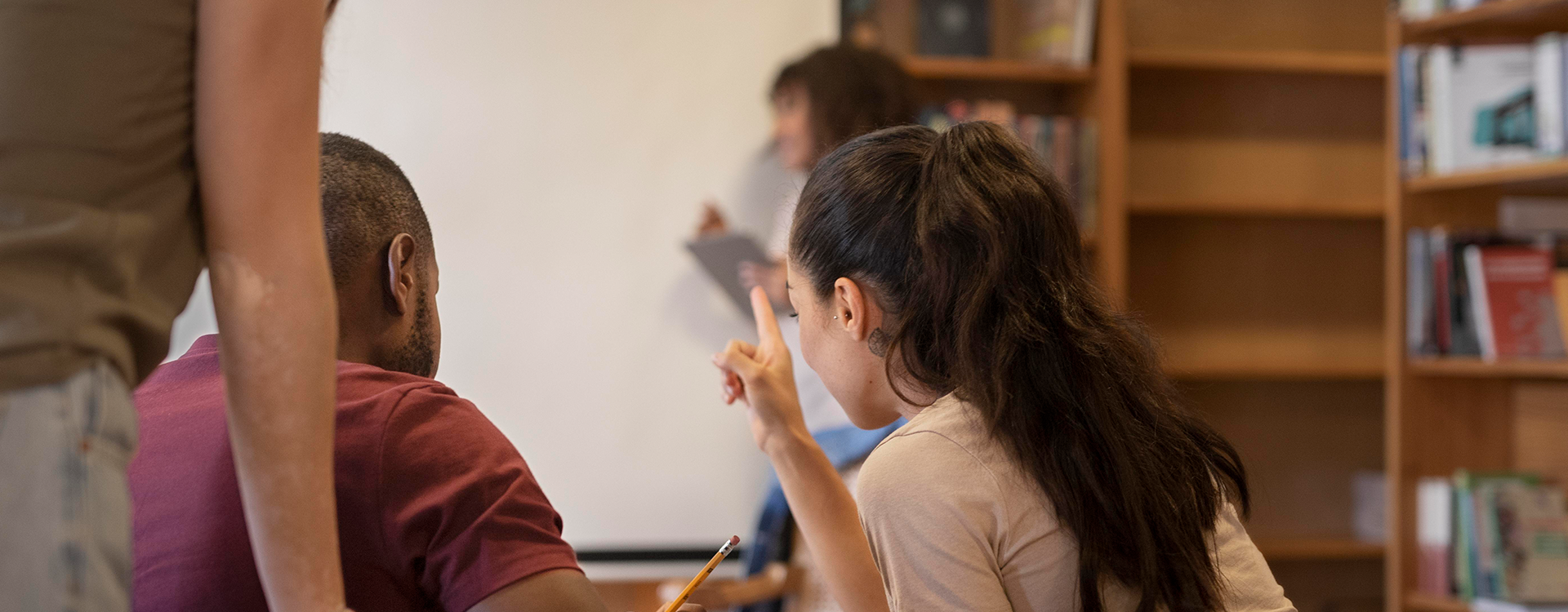 Profesora imparte clases a migrantes.